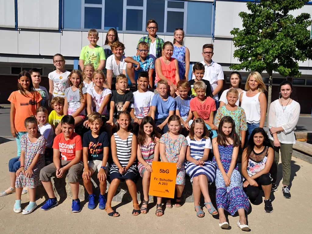 Klassenfoto einer neuen fünften Klasse vor dem Schulgebäude.